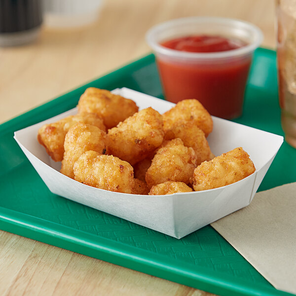 A white paper food tray with tater tots and ketchup.