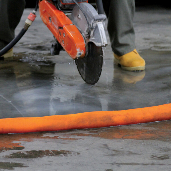 A person using a circular saw to cut a black cable.