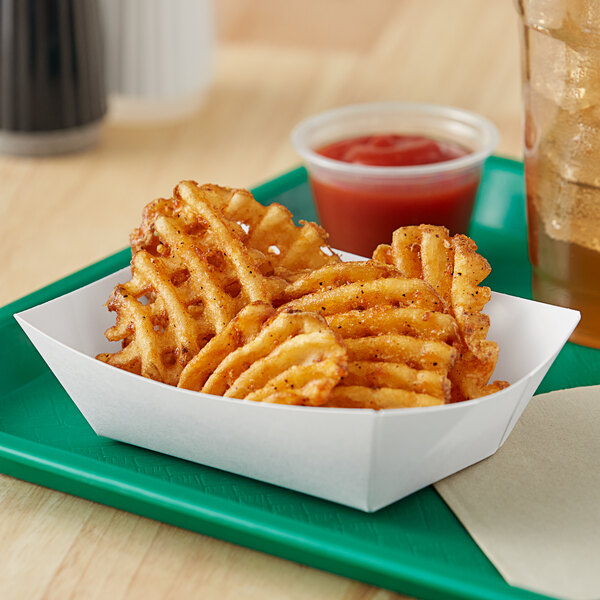A basket of french fries and ketchup on a white paper food tray.