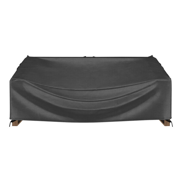 A black protective cover on a wooden table.