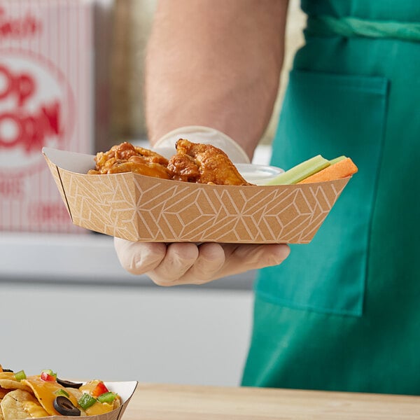 A person holding a Southern Champion paper food tray of food with a bowl of chips.