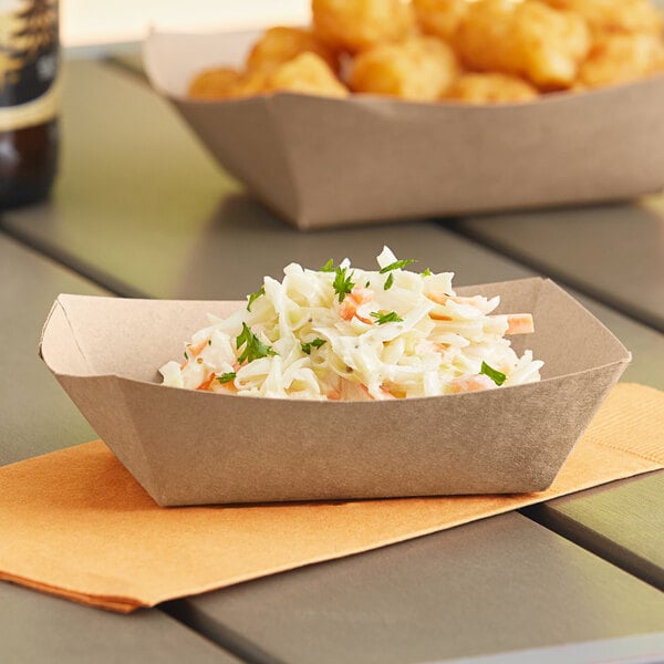 A Southern Champion paper food tray with a bowl of coleslaw, tater tots, and chicken nuggets.