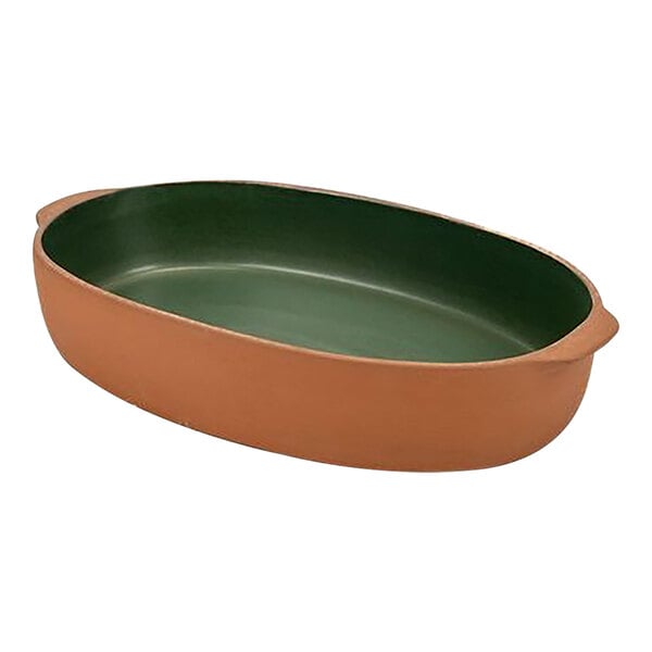 An oval terracotta stoneware baker with green and brown sides.