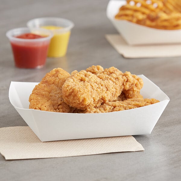 A bowl of chicken strips in a Southern Champion white paper food tray with tomato sauce.