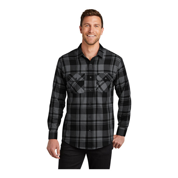 A man wearing a black and grey plaid Port Authority flannel shirt.