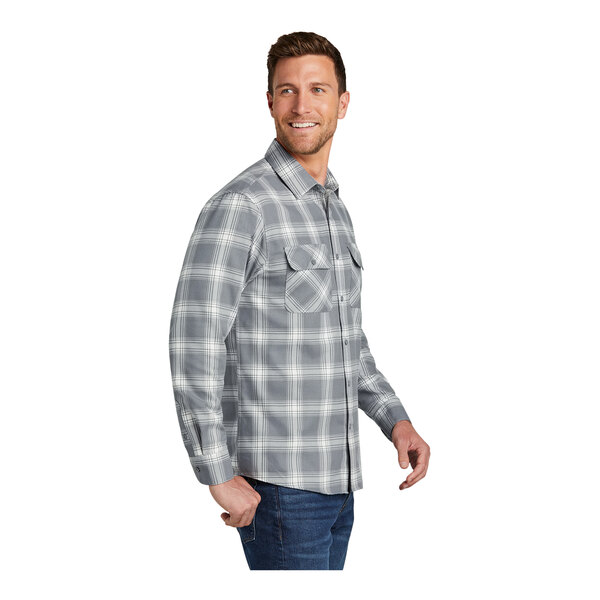 A man wearing a gray and cream Port Authority plaid flannel shirt.