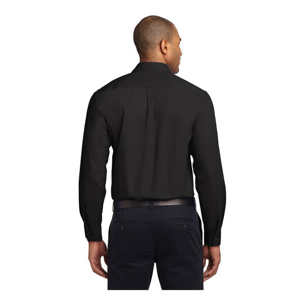A man wearing a black Port Authority long sleeve dress shirt.
