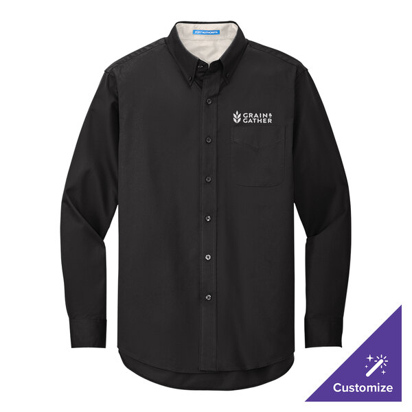 A black Port Authority long sleeve dress shirt on a counter with a logo on the chest.