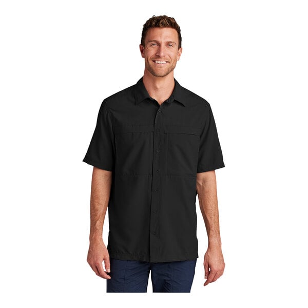 A man wearing a Port Authority short sleeve black shirt.