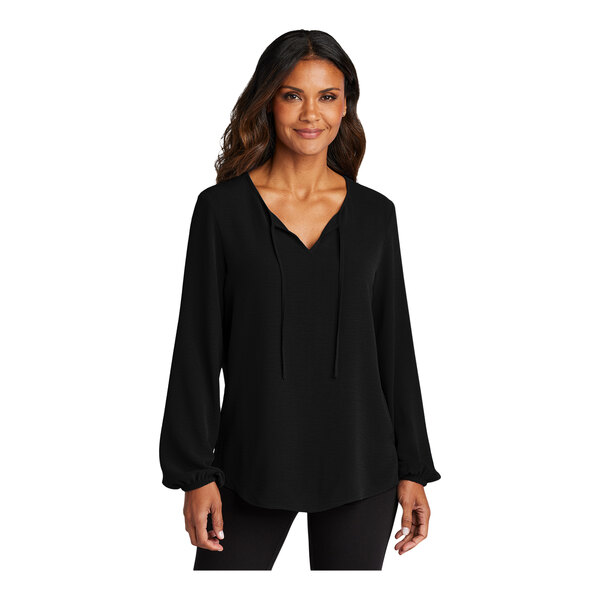 A woman wearing a black short sleeve blouse with a v-neck.