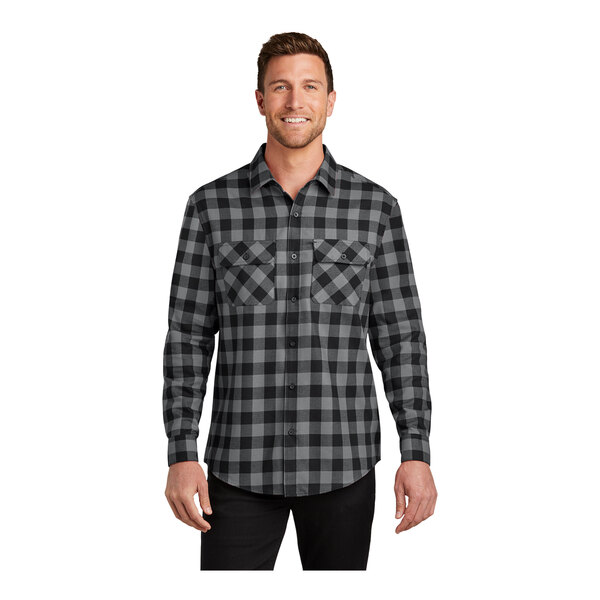 A man wearing a grey and black plaid Port Authority flannel shirt.