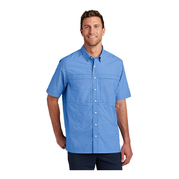 A man wearing a blue and white checkered short sleeve Port Authority shirt.