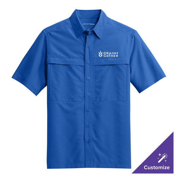 A blue Port Authority short sleeved shirt with a logo on the chest.