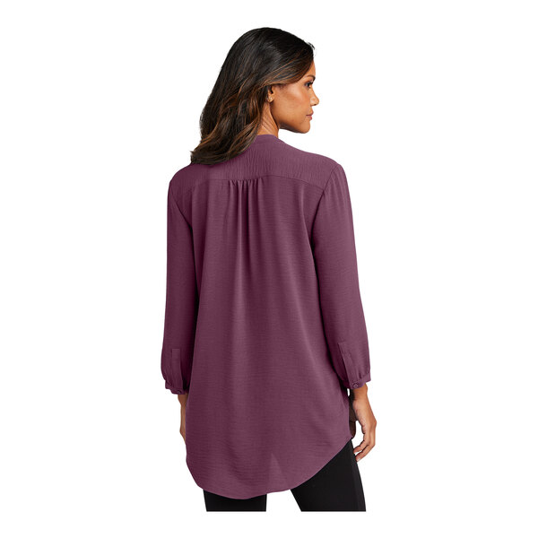 A woman wearing a purple Port Authority blouse.