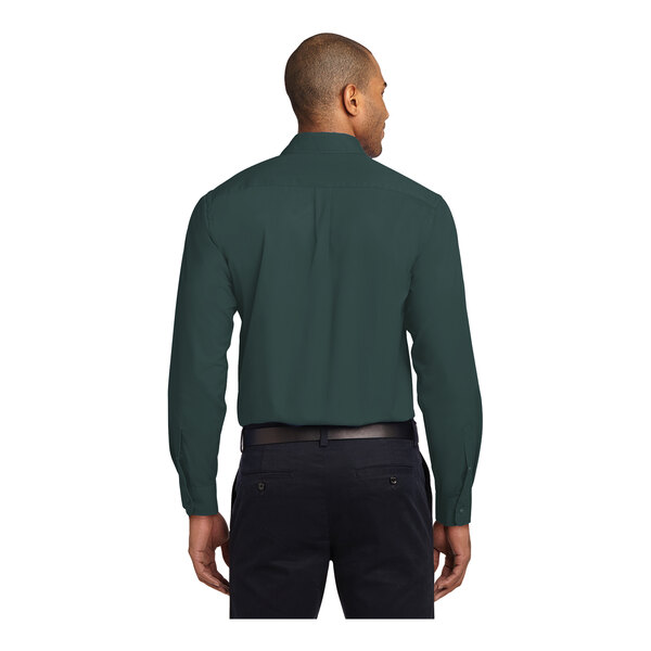 A man wearing a dark green Port Authority long sleeve dress shirt.