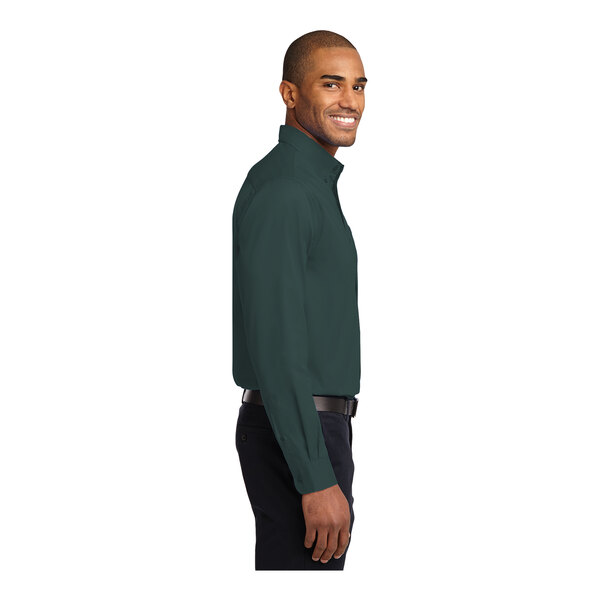 A man wearing a Port Authority dark green long sleeve dress shirt.