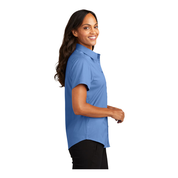 A woman wearing a Port Authority ultramarine blue short sleeve dress shirt.