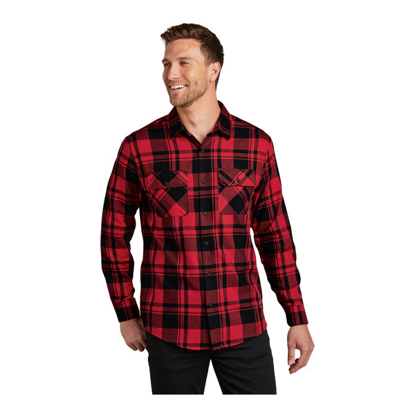 A man wearing a Port Authority red and black plaid long sleeve flannel shirt.