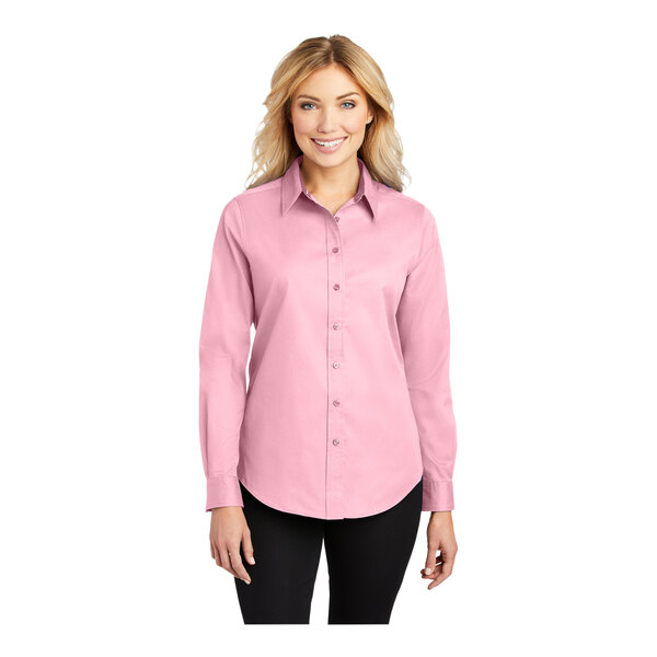 A woman wearing a Port Authority light pink long sleeve dress shirt.