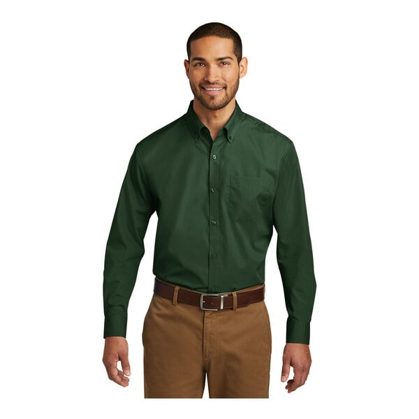 A man wearing a Port Authority deep forest green long sleeve poplin shirt.