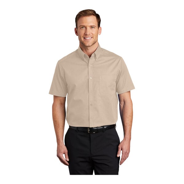 A man wearing a Port Authority short sleeve dress shirt in stone color.