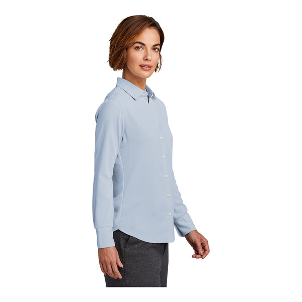 A woman wearing a blue Brooks Brothers long sleeve full-button satin blouse.