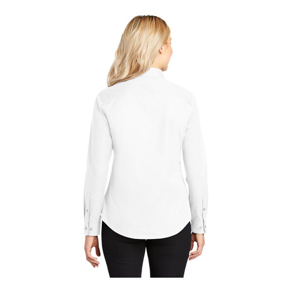 A woman wearing a white Port Authority long sleeve dress shirt.