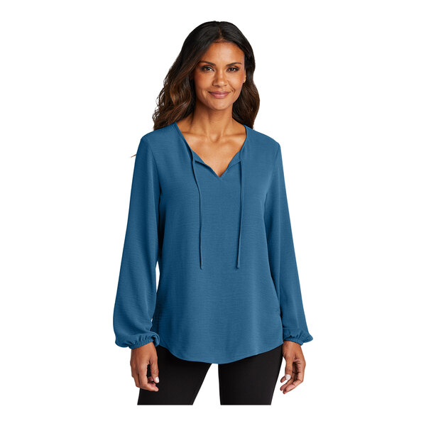 A woman wearing a blue short sleeve blouse.