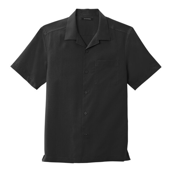 A black Port Authority short sleeve staff shirt with a collar and pocket on a counter.