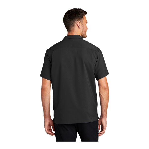 A man wearing a black Port Authority short sleeve staff shirt.