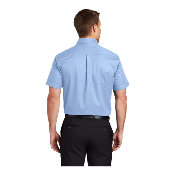 A man wearing a light blue and light stone Port Authority short sleeve dress shirt.