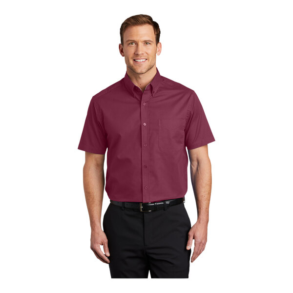 A man wearing a burgundy and light stone Port Authority dress shirt with short sleeves.