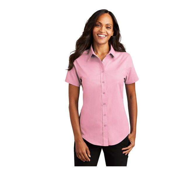 A woman wearing a light pink Port Authority short sleeve dress shirt.