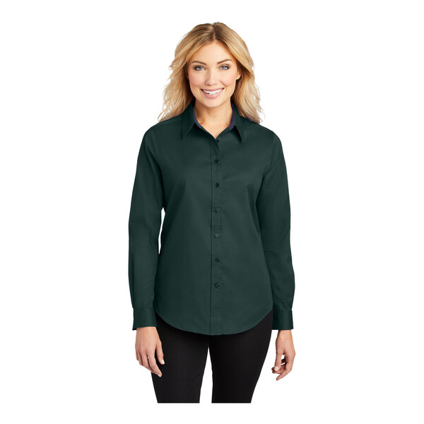 A woman wearing a dark green Port Authority long sleeve dress shirt.