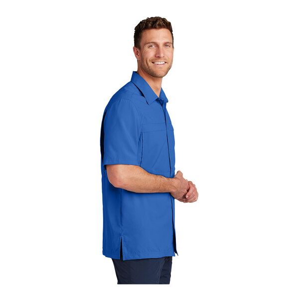 A man wearing a Port Authority True Royal short sleeve performance shirt.