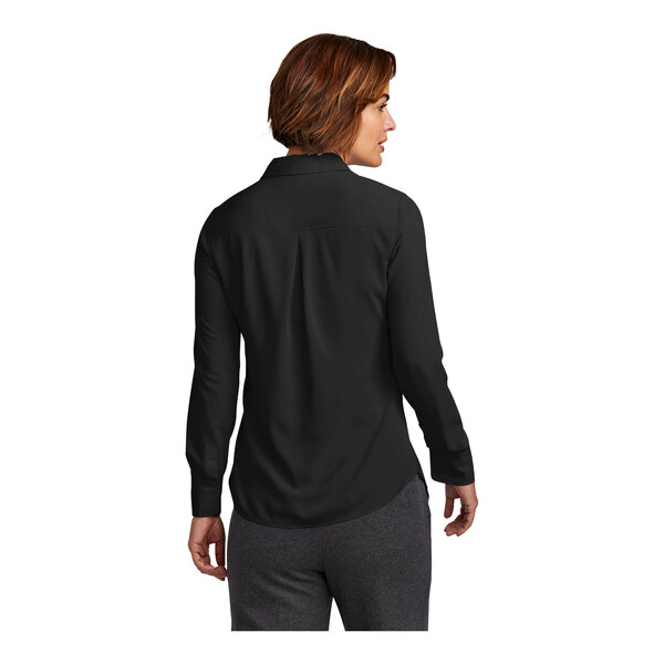 A woman wearing a black Brooks Brothers long sleeve satin shirt.