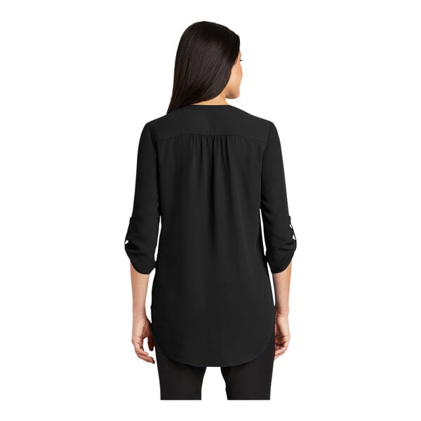 A woman wearing a black short sleeve blouse.