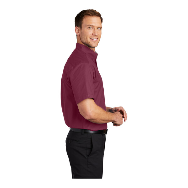 A man wearing a Port Authority burgundy and light stone dress shirt.