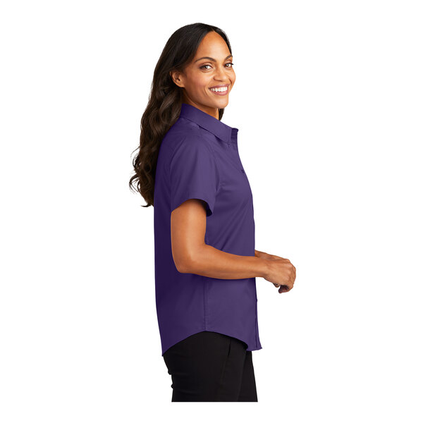 A woman wearing a purple Port Authority dress shirt with a light stone collar and cuffs.