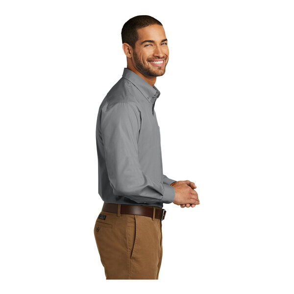 A man wearing a Port Authority long sleeve poplin shirt in Gusty Gray.