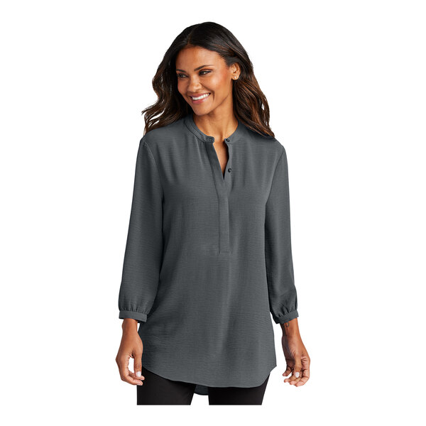 A woman wearing a graphite Port Authority short sleeve blouse.
