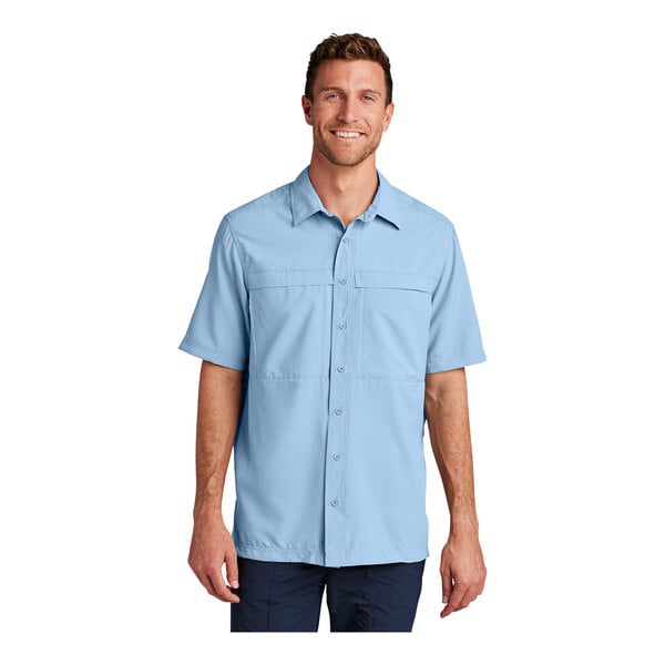 A man wearing a light blue Port Authority short sleeve shirt.