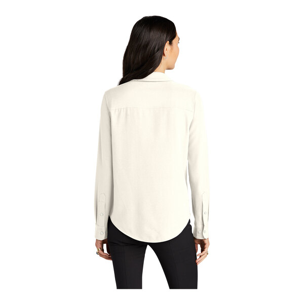 A woman wearing a Mercer+Mettle ivory chiffon long sleeve blouse with a buttoned collar.