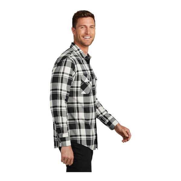 A man wearing a Port Authority snow white and black plaid flannel shirt.
