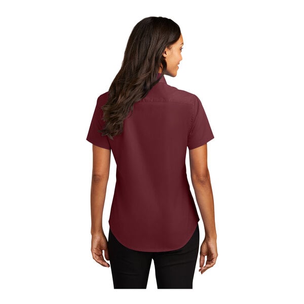 A woman wearing a Port Authority burgundy and light stone short sleeve dress shirt.