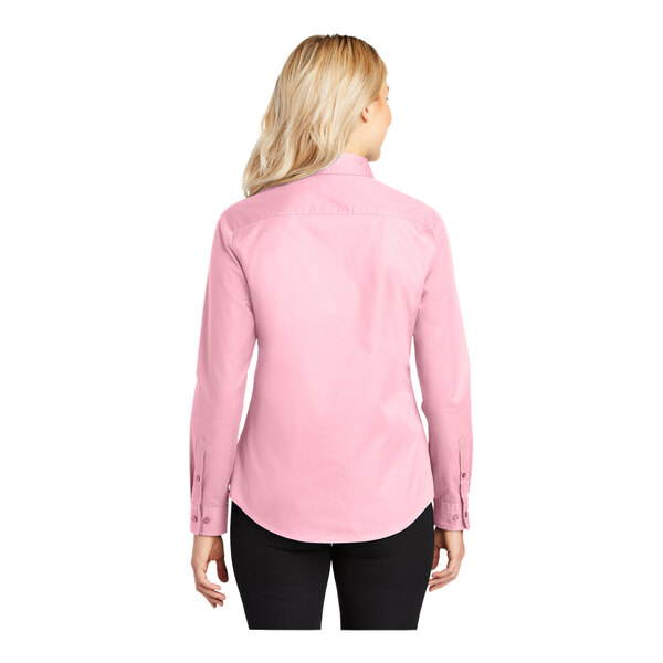 A woman wearing a light pink Port Authority long sleeve dress shirt.