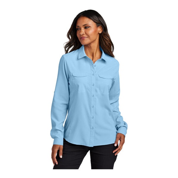 A woman wearing a light blue Port Authority short sleeve shirt.