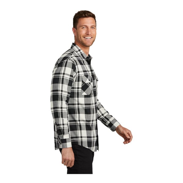 A man wearing a Port Authority black and white plaid flannel shirt.