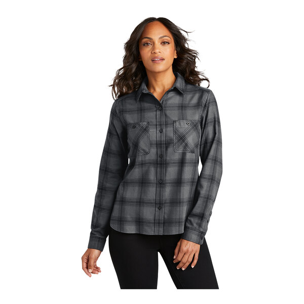 A woman wearing a gray and black Port Authority long sleeve plaid flannel shirt.