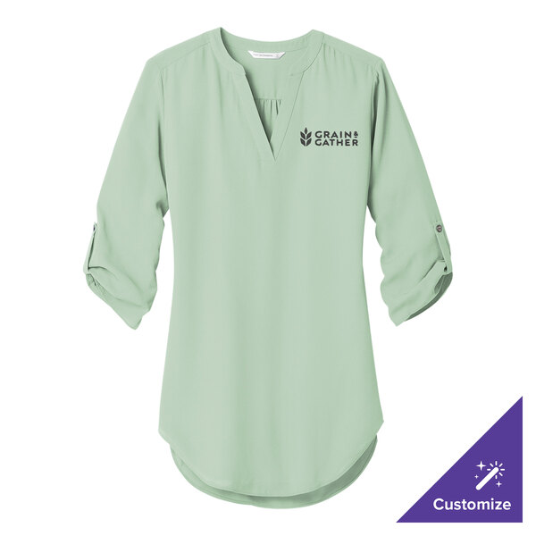 A light green Port Authority tunic shirt with white text on the front.